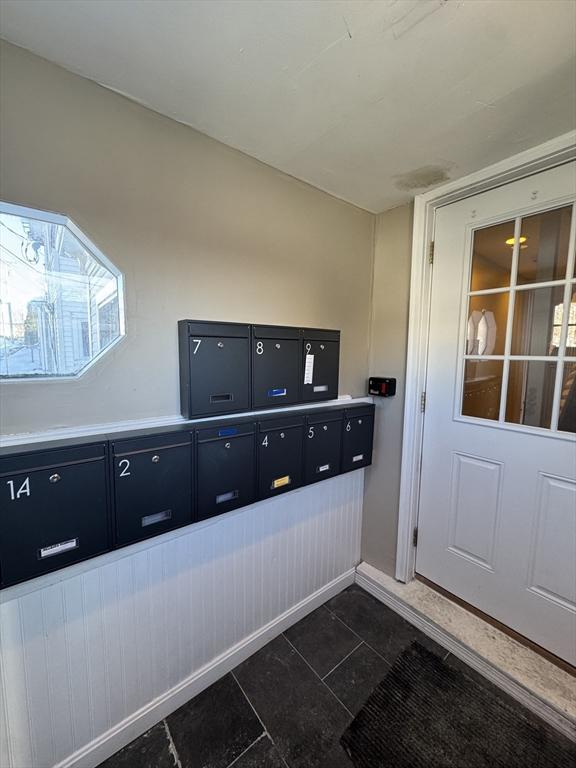 mudroom with dark tile patterned floors