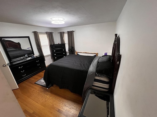 bedroom with a textured ceiling and hardwood / wood-style flooring