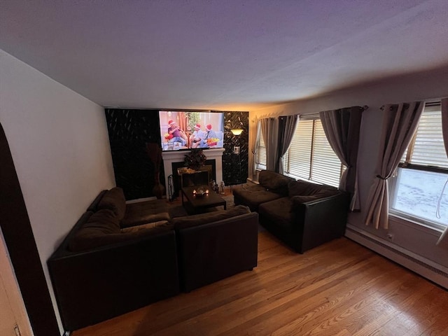 living room featuring hardwood / wood-style floors and a baseboard heating unit