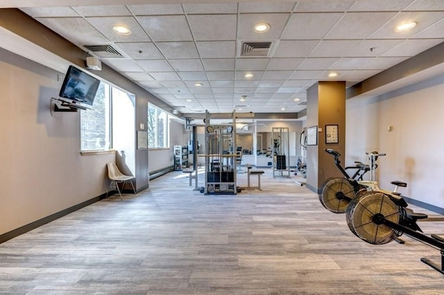 gym with wood finished floors, baseboards, and a drop ceiling