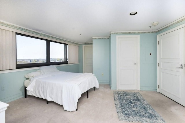 bedroom with light colored carpet and baseboards