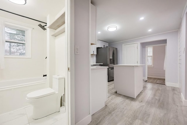 73 Laurie Ave, Abington, MA 02351 - bathroom featuring wood finished floors, a tub, crown molding, and a healthy amount of sunlight