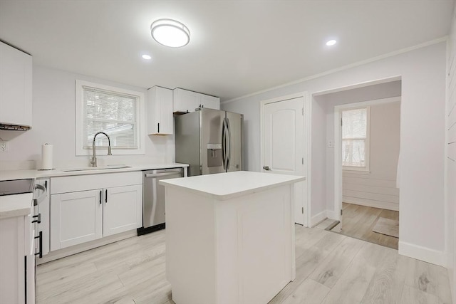73 Laurie Ave, Abington, MA 02351 - kitchen featuring a center island, appliances with stainless steel finishes, light countertops, a sink, and light wood finished floors