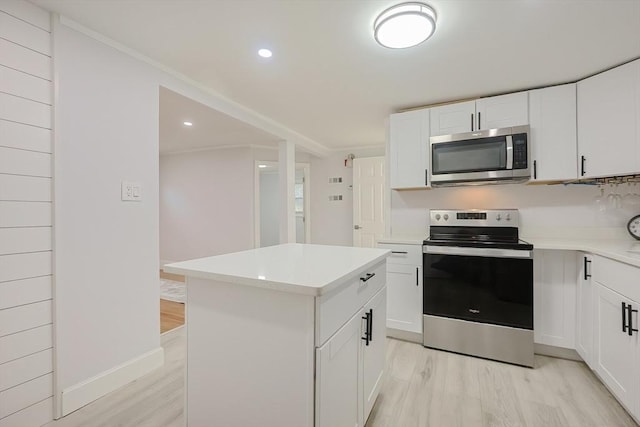 73 Laurie Ave, Abington, MA 02351 - kitchen with light wood-style floors, a kitchen island, light countertops, and stainless steel appliances