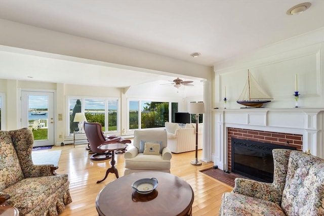 188 S St, Yarmouth, MA 02664 - living area featuring a fireplace, a baseboard radiator, light wood finished floors, and ceiling fan