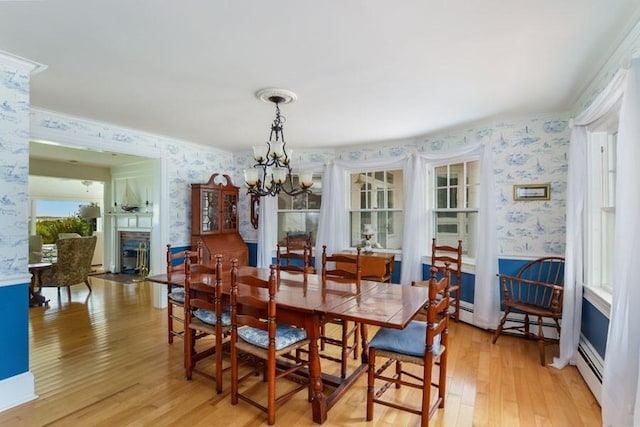 188 S St, Yarmouth, MA 02664 - dining room with light wood-style flooring, wallpapered walls, a fireplace, and a chandelier