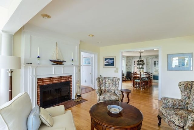188 S St, Yarmouth, MA 02664 - living room with a fireplace, light wood-style flooring, and a chandelier