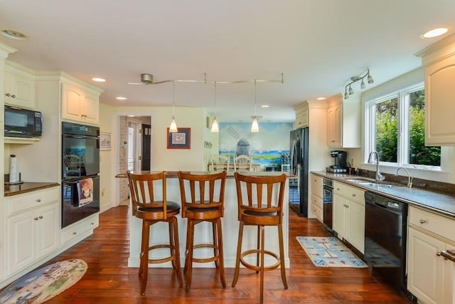 188 S St, Yarmouth, MA 02664 - kitchen featuring a kitchen bar, a center island, dark wood finished floors, a sink, and black appliances