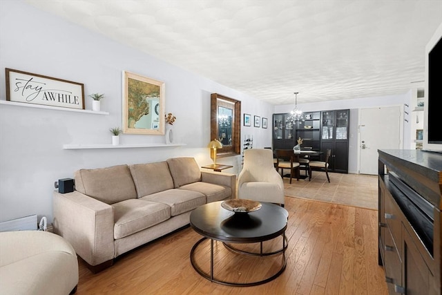 living room with light hardwood / wood-style flooring and a chandelier