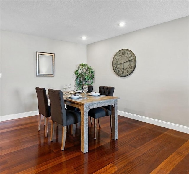 dining area featuring hardwood / wood-style flooring and a textured ceiling