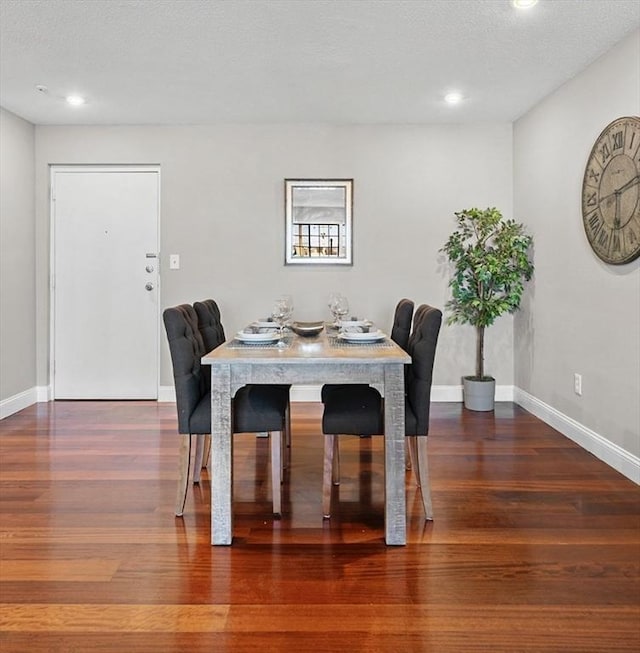 dining space featuring a textured ceiling and dark hardwood / wood-style floors