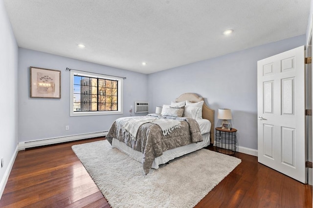 bedroom featuring a wall unit AC, a baseboard heating unit, and dark hardwood / wood-style flooring