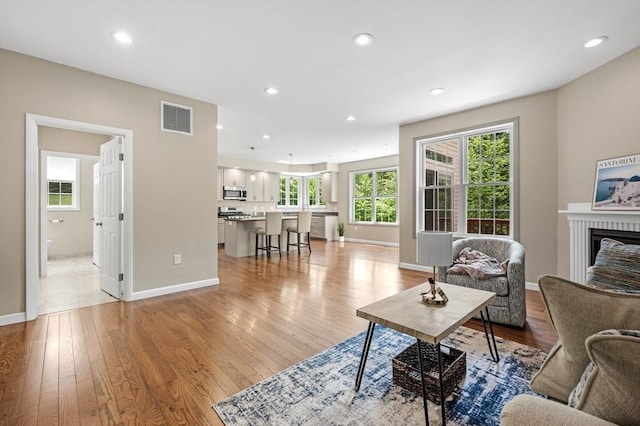 233A Green St Unit A, Boylston, MA 01505 - living room with light wood-type flooring, a brick fireplace, baseboards, and recessed lighting