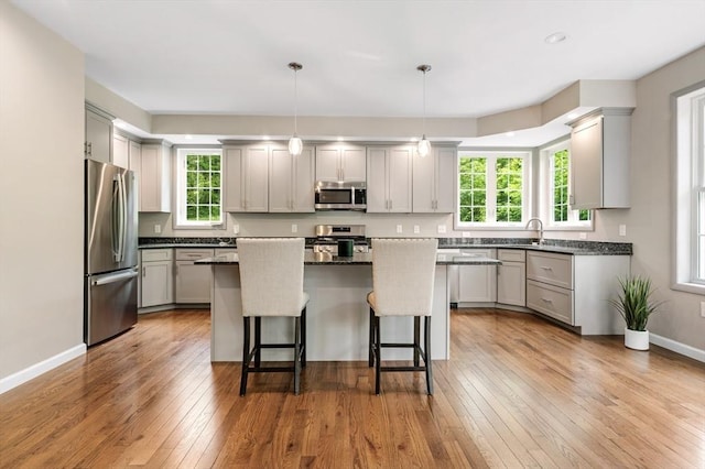 233A Green St Unit A, Boylston, MA 01505 - kitchen with stainless steel appliances, a breakfast bar area, light wood-style floors, a center island, and a sink