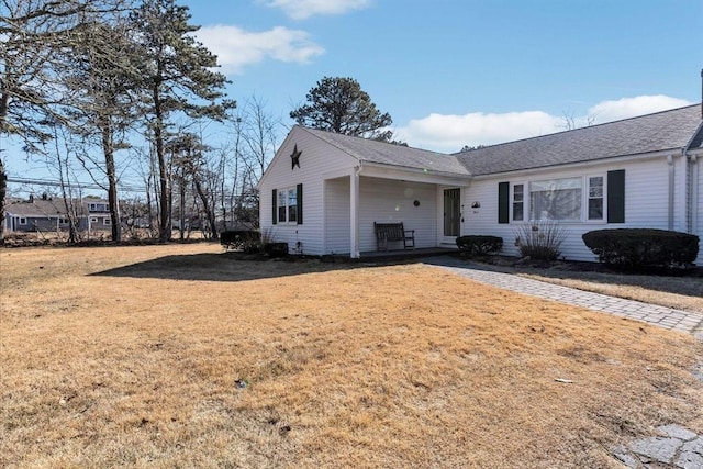 ranch-style house with a front yard and roof with shingles