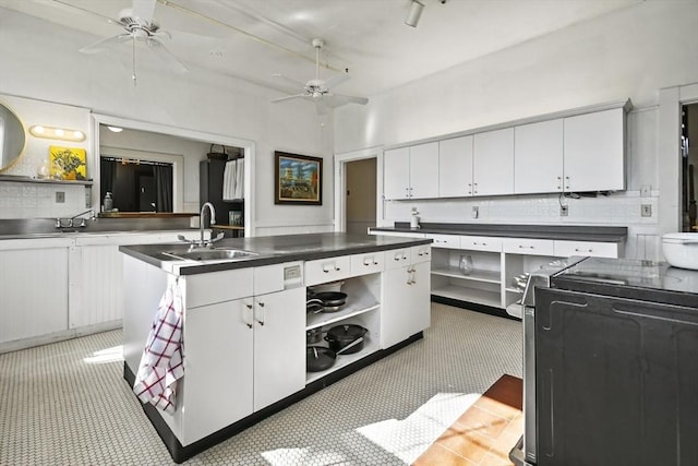 824 Tucker Rd, Dartmouth, MA 02747 - kitchen with a sink, stove, stainless steel countertops, ceiling fan, and white cabinetry