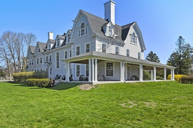 824 Tucker Rd, Dartmouth, MA 02747 - back of property with a chimney, a yard, a gambrel roof, and a patio area