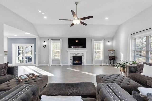 living area featuring ceiling fan, vaulted ceiling, a wealth of natural light, and wood finished floors