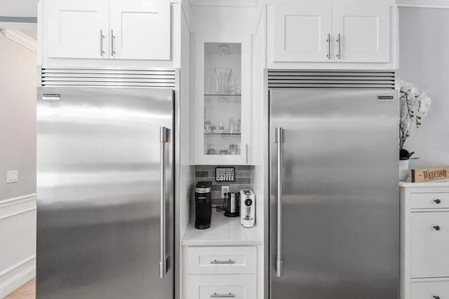 kitchen featuring stainless steel built in fridge and white cabinets