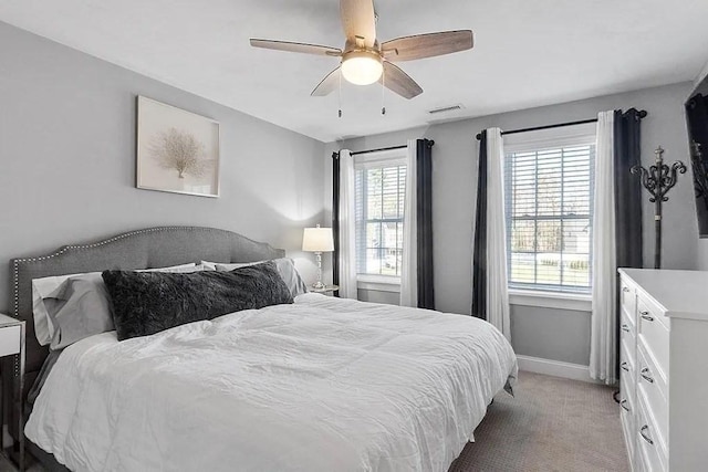 bedroom featuring baseboards, visible vents, light carpet, and ceiling fan