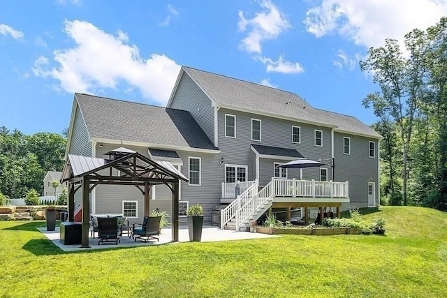 rear view of house featuring a wooden deck, a gazebo, a yard, and a patio area