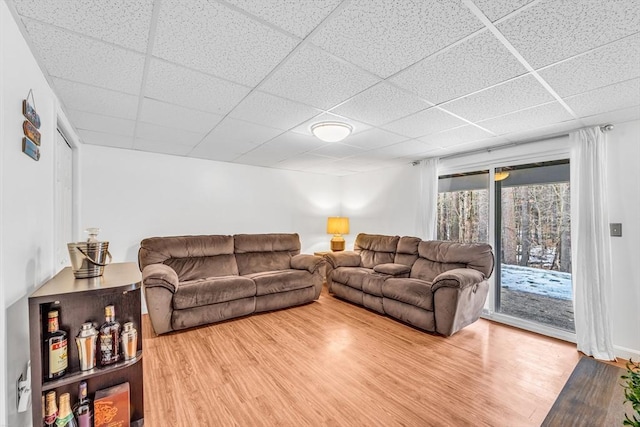 living area featuring a paneled ceiling and wood finished floors