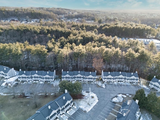 drone / aerial view featuring a wooded view and a residential view