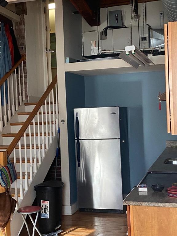 kitchen with sink, wood-type flooring, and stainless steel refrigerator