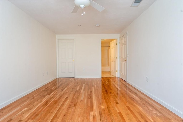 unfurnished bedroom featuring baseboards, ceiling fan, visible vents, and light wood-style floors