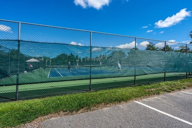 view of tennis court featuring fence