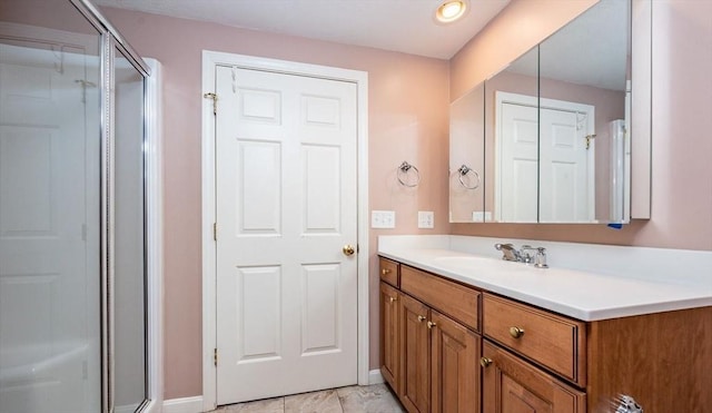 full bath with a stall shower, vanity, and baseboards