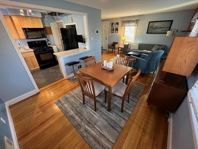 dining room with baseboards and wood finished floors