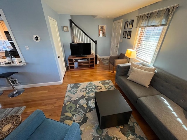 living area featuring stairway, wood finished floors, and baseboards