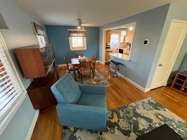 dining space with baseboards and wood finished floors