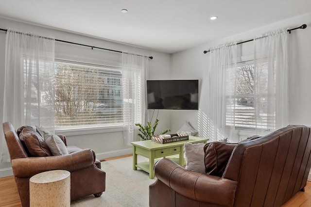 living room with a wealth of natural light and light hardwood / wood-style floors