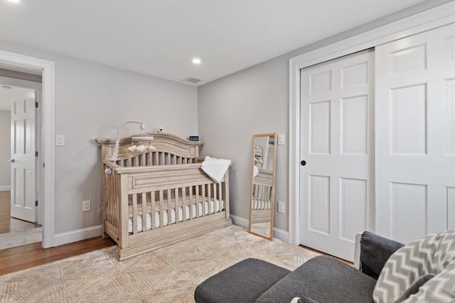 bedroom with light hardwood / wood-style floors and a closet