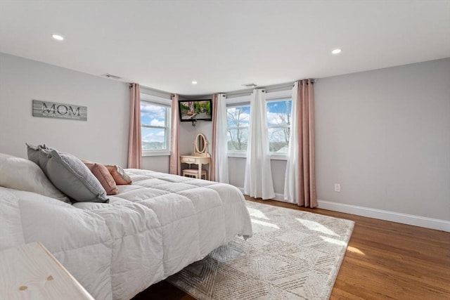 bedroom featuring multiple windows and hardwood / wood-style flooring