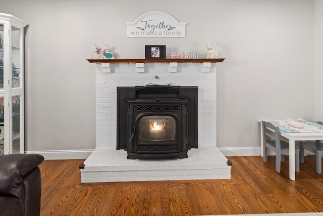 interior details with wood-type flooring and a wood stove