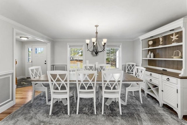 dining area with a wainscoted wall, dark wood-style flooring, and crown molding