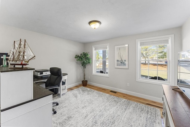 office space with visible vents, baseboards, and wood finished floors