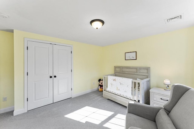 carpeted bedroom with a closet, visible vents, and baseboards