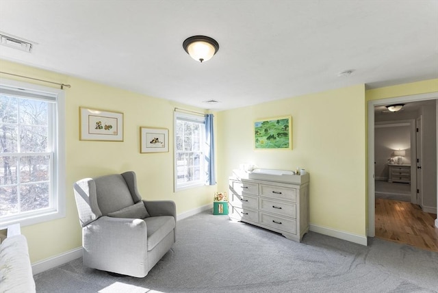 sitting room with a wealth of natural light, visible vents, and baseboards