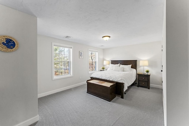 bedroom with visible vents, a textured ceiling, baseboards, and carpet floors