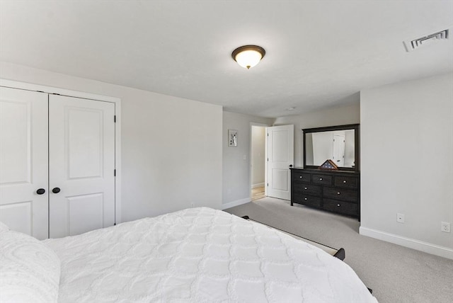 bedroom featuring a closet, visible vents, baseboards, and carpet floors