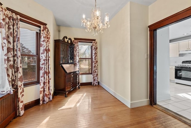 hall featuring light hardwood / wood-style floors and a notable chandelier