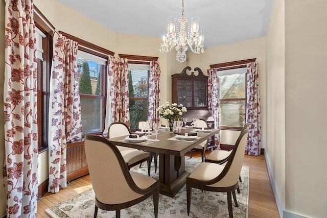 dining area featuring light hardwood / wood-style floors and a notable chandelier