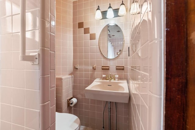 bathroom featuring tile walls, sink, and toilet