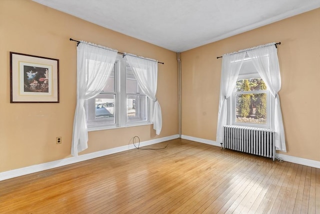 unfurnished room featuring hardwood / wood-style flooring and radiator