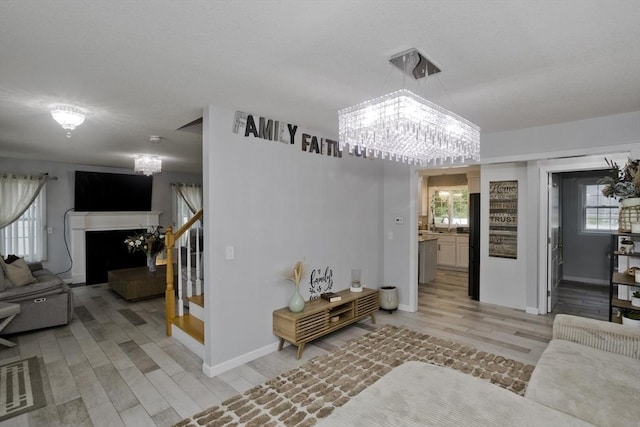 210 Naismith, Springfield, MA 01104 - living room featuring stairway, light wood-style floors, a chandelier, and a fireplace