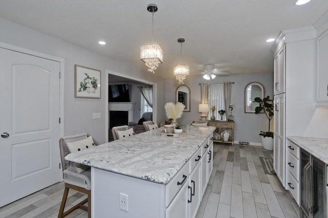 210 Naismith, Springfield, MA 01104 - kitchen featuring a breakfast bar, white cabinetry, a kitchen island, light wood finished floors, and recessed lighting